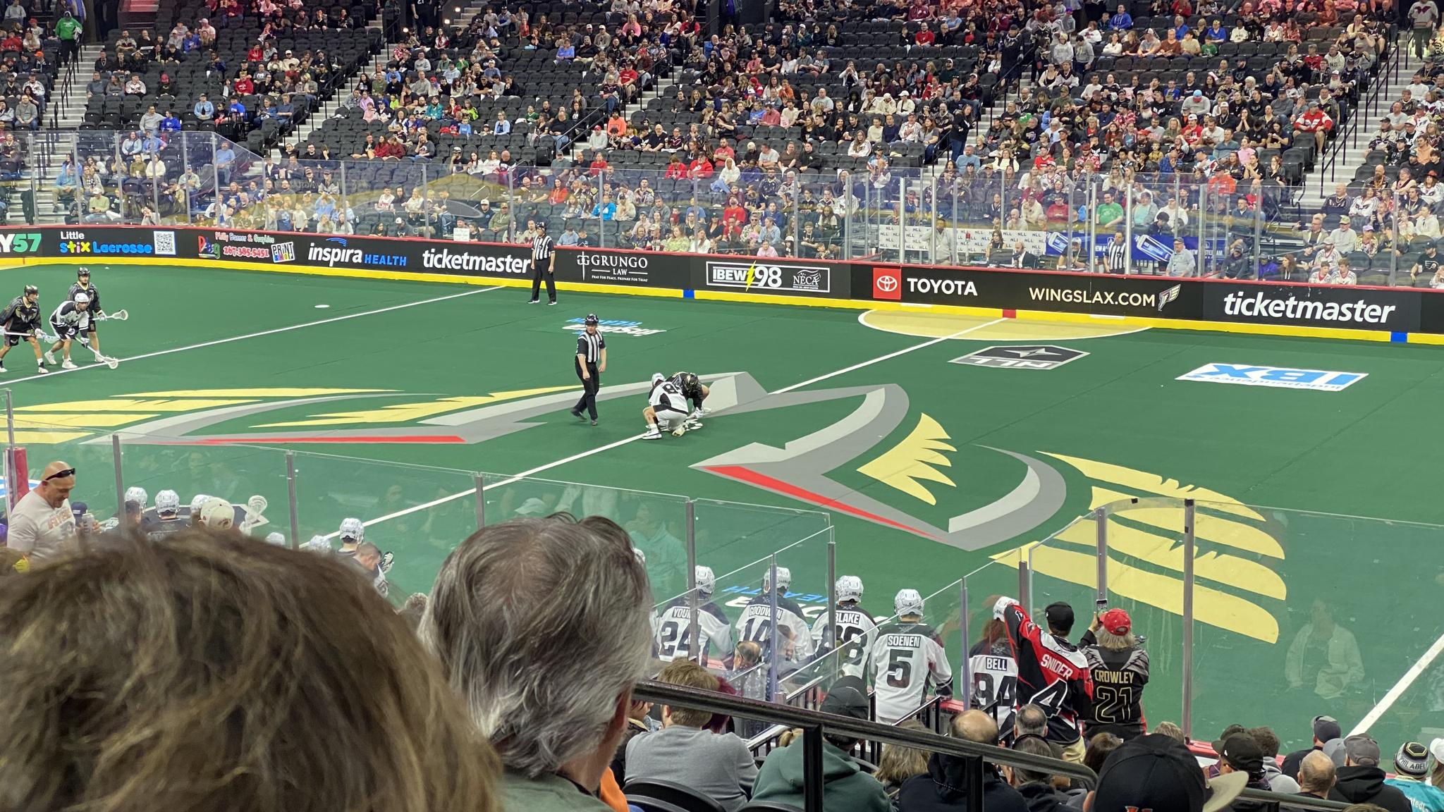 A photo of the opening faceoff of a box lacrosse game