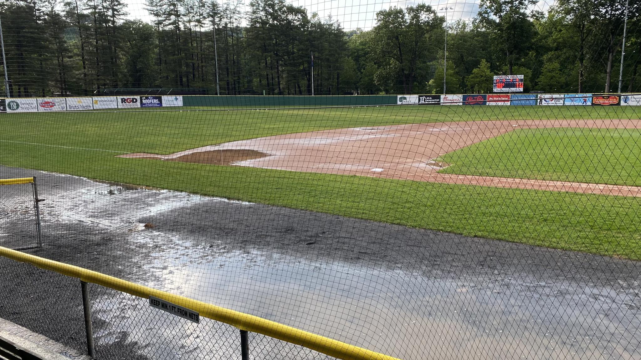 A photo of a large puddle on the dirt of a baseball diamond